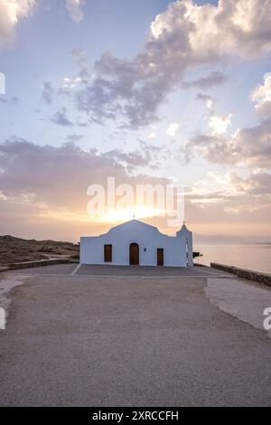 Piccola chiesa bianca in tipico stile architettonico greco, situata su una roccia lavica, circondata dal Mar Mediterraneo, Cappella di Agios Nikolaos all'alba, Zante, Isole Ionie, Grecia Foto Stock