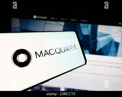 Telefono cellulare con logo della società finanziaria australiana Macquarie Group Limited davanti al sito web. Mettere a fuoco la parte centrale sinistra del display del telefono. Foto Stock