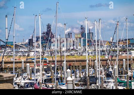 Porto marittimo Marina IJmuiden, Sportboothafen, Segelboote, Yachten, hinten das Tata Steel Stahl- und Hüttenwerk in IJmuiden, Velsen, Nordholland, Niederlande, größtes Industriegebiet in den Niederlanden, 2 Hochöfen, 2 Kokereien, Walzwerke, direkt an der Nordsee, Strandhäuser bei Ijmuiden aan Zee, Ijmuiden, Imuiden, barche a vela, marina ** dietro l'acciaieria Tata Steel e la fonderia di IJmuiden, Velsen, Olanda settentrionale, Paesi Bassi, la più grande area industriale dei Paesi Bassi, 2 altiforni, 2 cokerie, laminatoi, direttamente sul Mare del Nord, case sulla spiaggia di Ijmuid Foto Stock