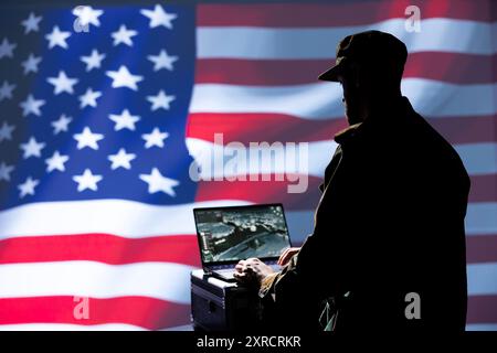 L'operativo dell'esercito USA NATO conduce ricognizioni tattiche, utilizzando laptop per l'analisi dei dati e la pianificazione della missione. Agente militare degli Stati Uniti che guarda la mappa aerea sullo schermo, individua gli obiettivi Foto Stock