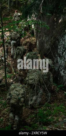 Soldati provenienti da tutta la 10th Mountain Division attraversano la bassa montagna Wolfjaw durante la Warrior Alpine Readiness Week Adirondack Lane vicino alla catena montuosa Adirondack, 8 agosto 2024. La corsia dell'Adirondack consisteva di più unità della 10th Mountain Division che attraversavano circa 20 miglia attraverso tre montagne diverse. La settimana della GUERRA, un evento di più giorni, crea una base per il clima freddo e le abilità di alpinismo, aumentando la letalità generale dei soldati della 10th Mountain Division sul moderno campo di battaglia. (Foto U.S. Army di SPC. Elijah Campbell) Foto Stock