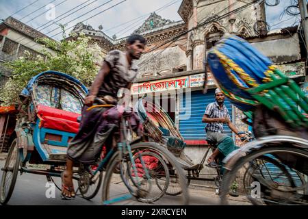 Pulitori di risciò per le strade di Puran Dhaka - Old Dhaka in Bangladesh. I risciò sono tricicli alimentati a pedale, ma usati per essere tirati a mano, da qui 'estrattore di risciò'. Oggi molti dei risciò sono persino convertiti per essere alimentati da un motore elettrico. Foto Stock