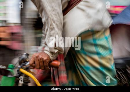 Pulitori di risciò per le strade di Puran Dhaka - Old Dhaka in Bangladesh. I risciò sono tricicli alimentati a pedale, ma usati per essere tirati a mano, da qui 'estrattore di risciò'. Oggi molti dei risciò sono persino convertiti per essere alimentati da un motore elettrico. Foto Stock