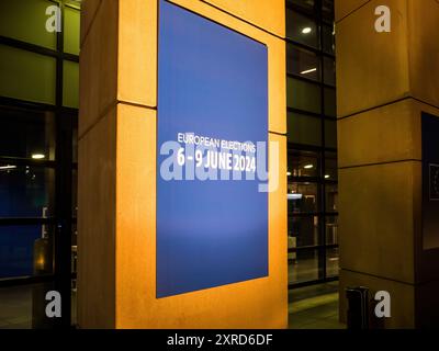 Strasburgo, Francia - 9 giugno 2024: Vicino all'ingresso di un grande edificio di vetro, che funge da postazione elettorale, viene esposto uno striscione che annuncia le elezioni europee del 6 e 9 giugno 2024, che mette in evidenza il prossimo evento democratico Foto Stock