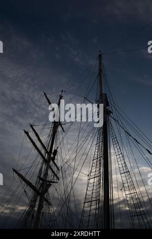 Un colpo di corde e l'armamento di una nave affiancata contro un cielo nuvoloso Foto Stock