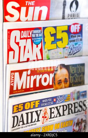 Scaffale di giornali che ospita diversi giornali britannici, tra cui edizioni di The Sun, Daily Star, Daily Mirror e Daily Express Foto Stock
