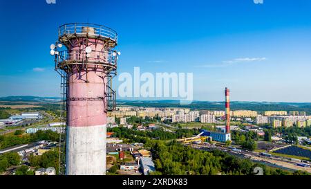 Vista aerea delle aree industriali con antenne da 5 g e del paesaggio urbano sotto un cielo azzurro Foto Stock