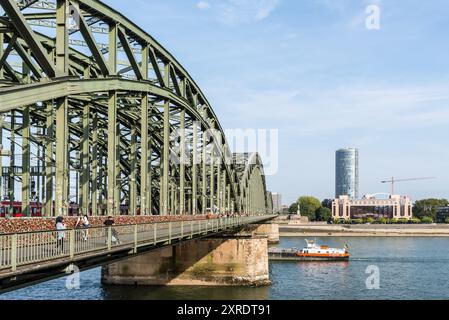 Colonia, Germania - 28 settembre 2023: Persone che camminano lungo il ponte Hohenzollern sul Reno e il treno che arriva alla stazione centrale di Colo Foto Stock