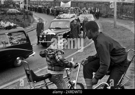 Il funerale di Blair Peach, un'insegnante della scuola di East London, ucciso nell'aprile 1979 durante la manifestazione anti-National Front a Southall, West London. Il corteo funebre si fa strada attraverso Southall sulla strada per il cimitero, hanno preso parte fino a 10.000 lutti. Due bambini sulle loro moto Chopper seguono il corteo e si fermano e chiacchierano mentre passano. Blair Peach era un membro attivo sia della Lega anti-nazista che della Inner London Teachers Association. Southall, Londra, Inghilterra 13 giugno 1979. 1970 UK HOMER SYKES Foto Stock