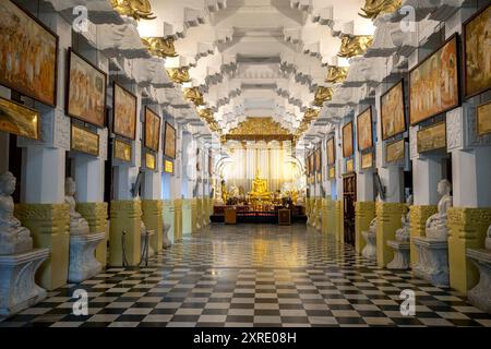 La vista si affaccia verso la statua dorata del Buddha seduto all'interno dell'Alut Maligiwa presso il Tempio della reliquia del Sacro dente a Kandy nello Sri Lanka. Foto Stock