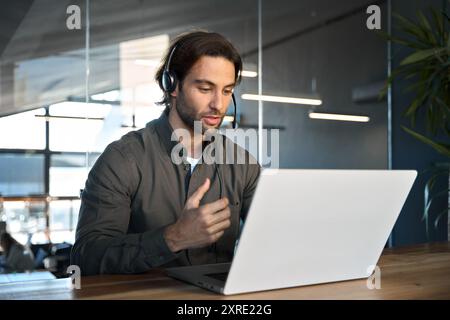 Un giovane professionista impegnato chiama un agente del contact centre che lavora in ufficio. Foto Stock