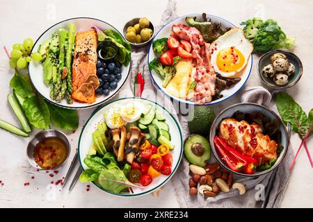 Cibo sano, dieta cheto, concetto di pranzo dietetico. Assortimento di vari cheto salutari mealsю Vista dall'alto su sfondo bianco. Foto Stock