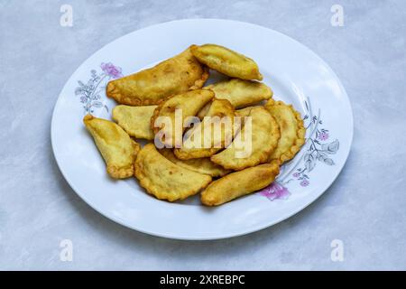 Delizioso puli pitha di manzo in un piatto. È una torta di riso tradizionale e popolare del Bangladesh. Foto Stock