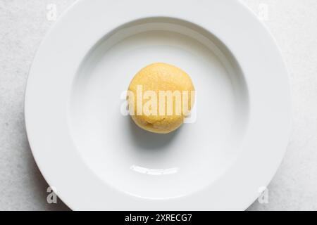 Vista dall'alto dell'EBA su un piatto bianco, garri nigeriani, vista dall'alto del garri giallo su un piatto bianco Foto Stock