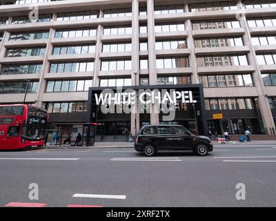 White Chapel Building, business Park a Whitechapel, Londra, con passaggio in primo piano di taxi nero Foto Stock