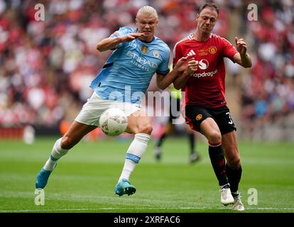 Erling Haaland (a sinistra) del Manchester City e Jonny Evans del Manchester United si battono per il pallone durante la partita di fa Community Shield al Wembley Stadium di Londra. Data foto: Sabato 10 agosto 2024. Foto Stock