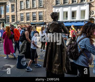 Royal Mile, Edimburgo, Scozia, Regno Unito, 10 agosto 2024. Festival Fringe di Edimburgo: Un artista di strada intrattiene la folla come una statua vivente di Marie Curie, affascinanti giovani. Crediti: Sally Anderson/Alamy Live News Foto Stock