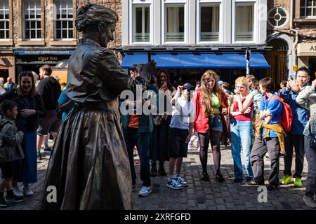 Royal Mile, Edimburgo, Scozia, Regno Unito, 10 agosto 2024. Festival Fringe di Edimburgo: Un artista di strada intrattiene la folla come una statua vivente di Marie Curie, affascinanti giovani. Crediti: Sally Anderson/Alamy Live News Foto Stock