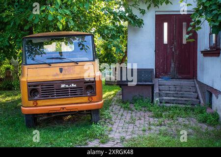 Camion d'epoca dell'Europa orientale che arrugginisce fuori da una casa abbandonata a Opoczno, Polonia centrale. Povertà, post-comunismo, decadenza, dimenticata. Foto Stock