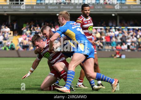 Leeds, Regno Unito. 10 agosto 2024. AMT Headingley Rugby Stadium, Leeds, West Yorkshire, 10 agosto 2024. Betfred Super League Leeds Rhinos contro Wigan Warriors Harry Smith di Wigan Warriors è placcato da James Bentley e James McDonnell di Leeds Rhinos Credit: Touchlinepics/Alamy Live News Foto Stock