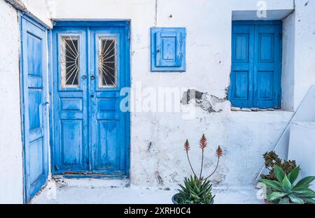 Vecchie porte e finestre blu nella vecchia casa sull'isola di Mykonos Foto Stock