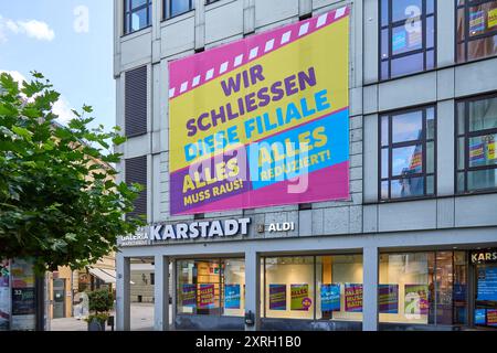 Augusta, Baviera, Germania - 10 agosto 2024: Il negozio Karstadt di Augusta pubblicizza vendite e sconti prima della sua imminente chiusura a causa dell'insolvenza della Galeria Kaufhof, con striscioni accattivanti che annunciano la vendita di liquidazione *** Karstadt-Filiale ad Augusta wirbt mit Schlussverkauf und Rabatten vor ihrer bevorstehenden Schließung aufgrund der Insolvenz von Galeria Kaufhof, mit auffälligen Bannern, die den Räumungsverkauf ankündigen Foto Stock