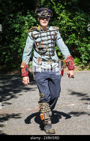 Henrichenburg, Waltrop, Germania. 10 agosto 2024. Un partecipante all'outfit completo affronta il caldo a 30 gradi. I fan dello steampunk, i gruppi e i visitatori, molti in costumi d'epoca retrò-futuristica o vittoriana, si divertiranno il primo giorno dell'annuale festival e mercato del Giubileo di Steampunk. Quest'anno, il festival coincide con il 125° anniversario dello storico impianto di risalita di Henrichenburg Boat Lift, sito patrimonio industriale lungo il canale Dortmund-EMS. Crediti: Imageplotter/Alamy Live News Foto Stock