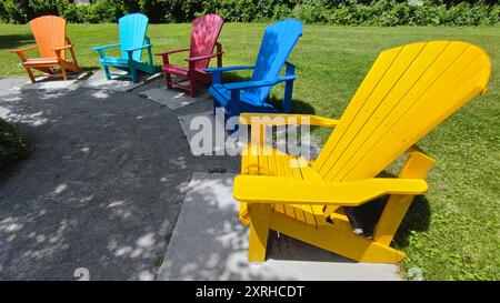 Sminuente vista prospettica delle sedie Adirondack multicolore nel parco pubblico Foto Stock