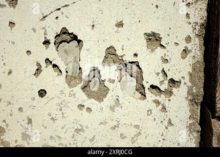 La parete in gesso mostra usura con patch e consistenza dovute all'età e all'esposizione. Foto Stock