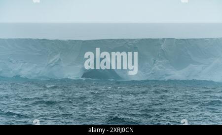 A23a Iceberg Antartide Ice Cave Close up Rough Seas Moody Clouds Fog and Dark Ocean. Vista panoramica delle crociere sulla piattaforma di ghiaccio Climate Change Foto Stock