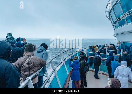 Antartide - 26 dicembre 2023 - foto di A23a Iceberg dalla nave da crociera dietro la folla di passeggeri. Vedono fotografare un enorme ghiaccio galleggiante Foto Stock