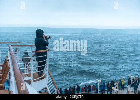 Antartide - 26 dicembre 2023 - foto di A23a Iceberg dalla nave da crociera dietro folla. Fotografie dei passeggeri dalla fotocamera della scalinata Foto Stock