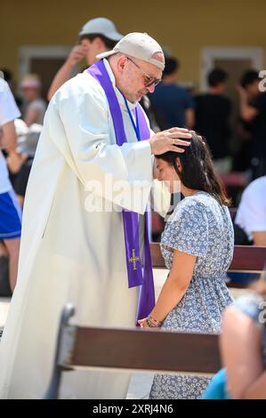 Un sacerdote cattolico che benedice e dà assoluzione a un penitente dopo la confessione a Medjugorje durante Mladifest 2024, la festa giovanile. Foto Stock