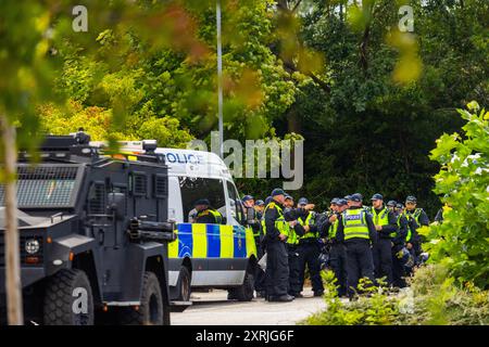 Wakefield, Regno Unito. 10 AGOSTO 2024. Briefing della polizia mentre oltre un centinaio di dimostranti si sono riuniti fuori dall'hotel Cedar Court in previsione di una folla di destra a causa del ruolo degli hotel nell'ospitare i migranti. I contro dimostranti erano composti da SUTR e altri gruppi di sinistra e tenevano discorsi. La presenza della polizia era eccezionalmente elevata, con 20 furgoni e 2 veicoli corazzati "Bearcat". Non sono arrivati manifestanti appoggiati all'ala destra e il contatore demo è andato via senza problemi. Credito Milo Chandler/Alamy Live News Foto Stock