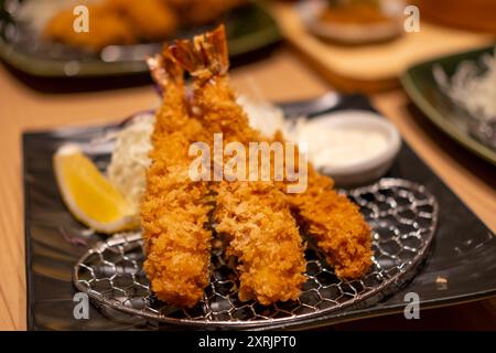 Gamberi fritti serviti su piatto con limone nel ristorante Foto Stock