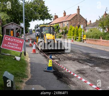 Trattore per lavori stradali con caricatore frontale, High Street, Cherry Willingham, Lincoln, Lincolnshire, Inghilterra, Regno Unito Foto Stock