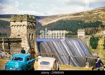 L'acqua scorre sopra la diga di Howden, il bacino idrico di Derwent, il parco nazionale di Peak District, Derbyshire, Inghilterra, la piattaforma di osservazione di 1956 auto d'epoca nel Regno Unito Foto Stock