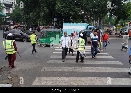 Dacca, Dacca, Bangladesh. 11 agosto 2024. L'11 agosto 2024, in seguito all'estromissione dell'ex primo ministro Sheikh Hasina il 5 agosto, l'intero paese ha assistito a una scena unica e stimolante per le strade di Dacca. Studenti di scuole, college e università di tutta la città scesero in strada per rivitalizzare il paese, impegnandosi in varie attività di volontariato. Negli incroci chiave e nei punti importanti della capitale, questi giovani volontari sono stati visti dirigere diligentemente il traffico, gestire i veicoli e assistere i pedoni. I loro sforzi non solo hanno evidenziato il loro senso di dovere civico bu Foto Stock