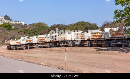 Dumper industriali parcheggiati in loco per lavori di terra su strada e autostrade in progetti di costruzione in corso. Foto Stock