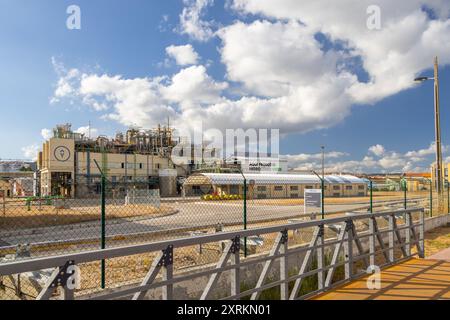 Impianto industriale che produce idrogeno verde sotto un cielo nuvoloso Foto Stock