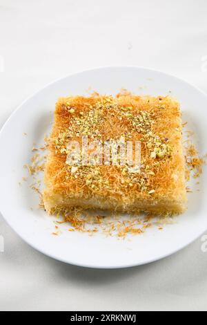 Dolci tradizionali arabi fatti in casa kunafa o noci knafeh sulla parte superiore, formaggio e sciroppo di zucchero, sul vassoio Foto Stock