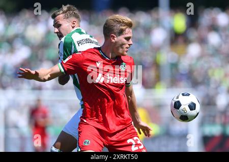 Fussball 2. Bundesliga 2. Spieltag SC Preussen Muenster - Hannover 96 am 11.08.2024 im Preussenstadion a Muenster Marcel Halstenberg ( Hannover ), vorne - Joel Grodowski ( Muenster ), le normative hinten DFL vietano qualsiasi uso di fotografie come sequenze di immagini e/o quasi-video. Foto: Revierfoto Foto Stock