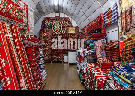 Negozio turco di tappeti antichi. Un mucchio di splendidi tappeti fatti a mano sul tradizionale bazar del mercato del Medio Oriente. Tappeti colorati turchi. Foto Stock