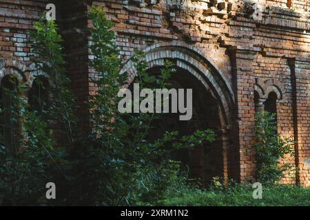 Il cancello della stalla. Una stalla in mattoni rossi in rovina. edifici del xix secolo Foto Stock