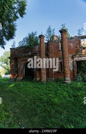 2 colonne all'ingresso. Stalla in mattoni rossi rovinati. La casa padronale di Kostrovitsky Foto Stock