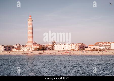 Sfumature del tramonto a Praia da barra: Una vista costiera con l'iconico faro (Ílhavo, Aveiro, Portogallo) Foto Stock