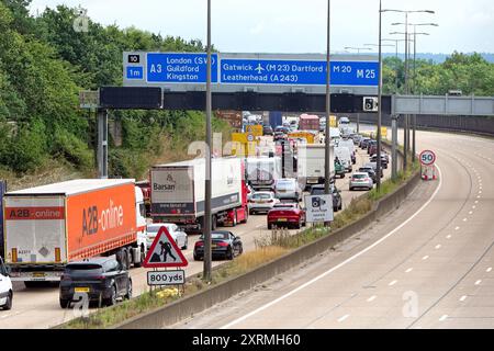 Forte traffico in senso antiorario durante l'avvicinamento alla strada allo svincolo 10 dell'autostrada M25 a Wisley Surrey Inghilterra Regno Unito Foto Stock