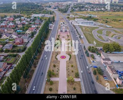 La foto aerea del parco commemorativo della Vittoria a Kursk, in Russia, con l'Arco di Trionfo della seconda guerra mondiale, le case residenziali e l'autostrada. Foto Stock