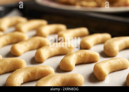 Mezzaluna dolci crude alla vaniglia o Kipferl, tradizionali biscotti natalizi, su una teglia da forno Foto Stock