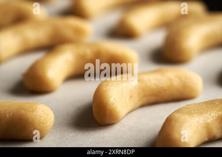 Primo piano di mezzalune di vaniglia crude fatte in casa o Kipferl, i tradizionali biscotti natalizi prima della cottura Foto Stock